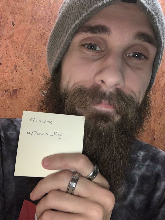 Bearded man wearing a beanie holding a note, part of the 80 people who asked the internet to toast them collection.