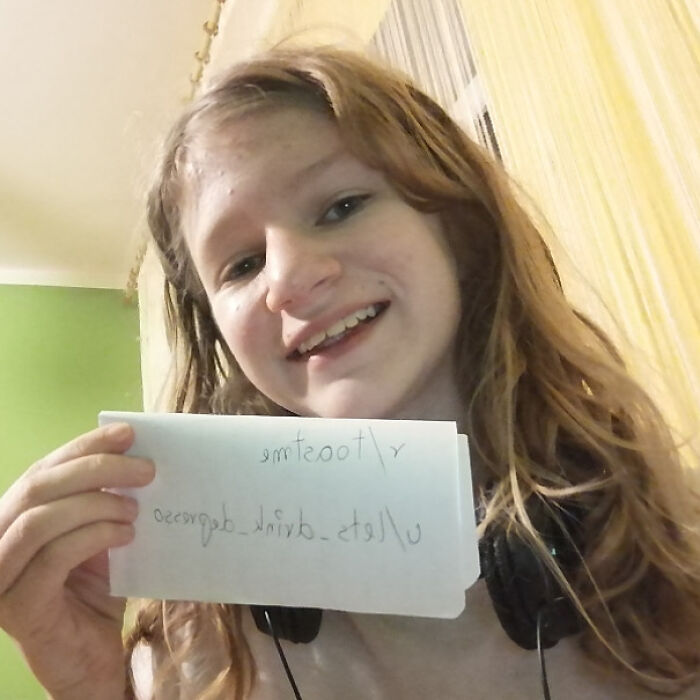 Smiling young person holding a handwritten note, part of a collection featuring people who asked the internet to toast them.