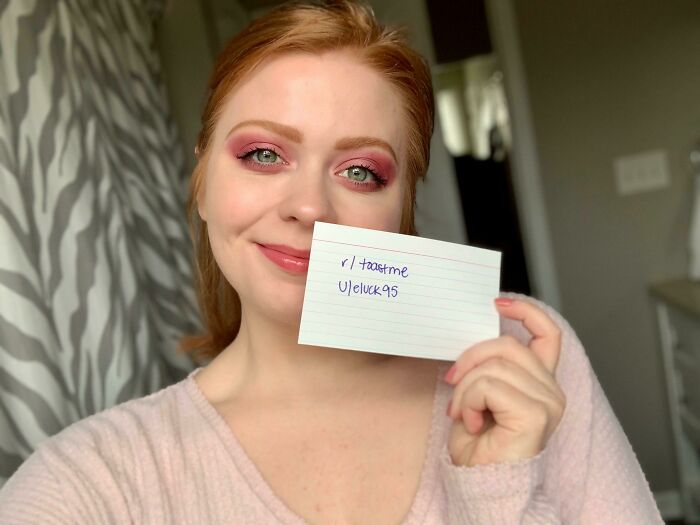 Woman smiling and holding a note for an internet toast request, part of 80 people who asked the internet to toast them.