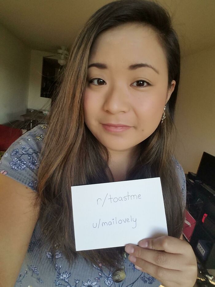 Young woman holding a sign asking the internet to toast her, part of popular toastme community posts.