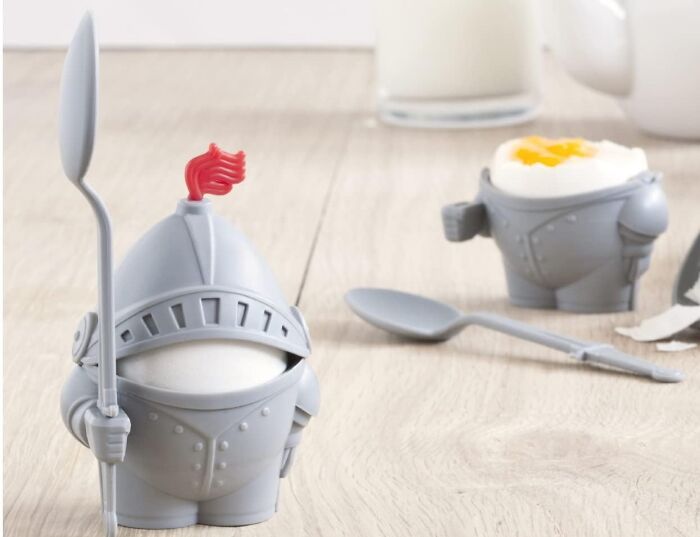 Knight-shaped egg holder with spoons on a wooden table, showcasing chaotic products you might want.