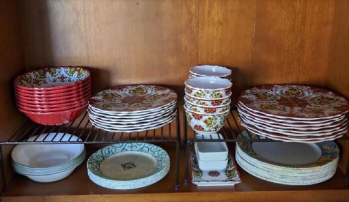 Colorful ceramic bowls and plates neatly stacked on wire racks in a kitchen cabinet kitchen finds people are obsessing over