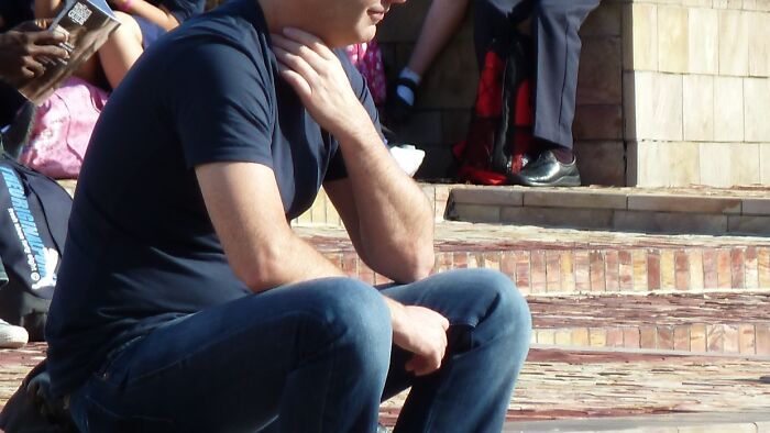 Man sitting on outdoor steps in casual clothing, appearing thoughtful, related to harsh when life gives you lemons advice.