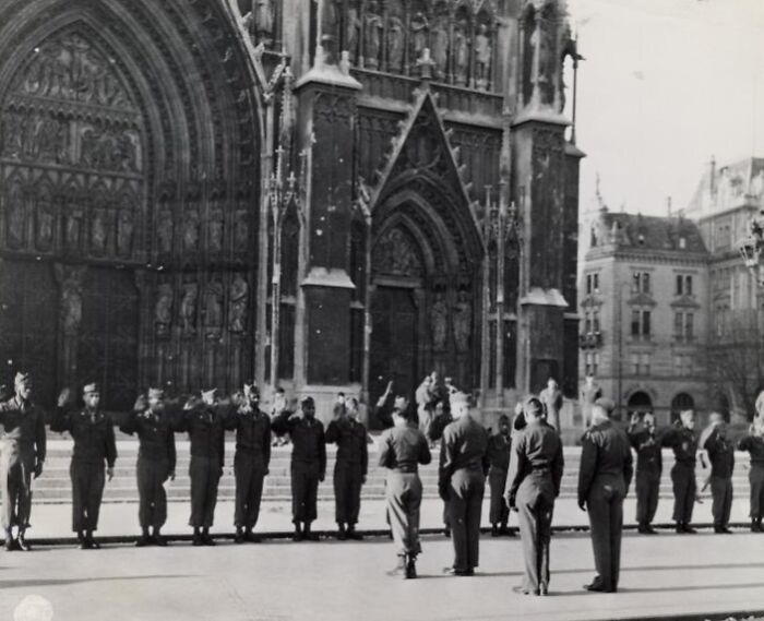 African American soldiers in uniform standing in formation outside a historic cathedral during a military ceremony.