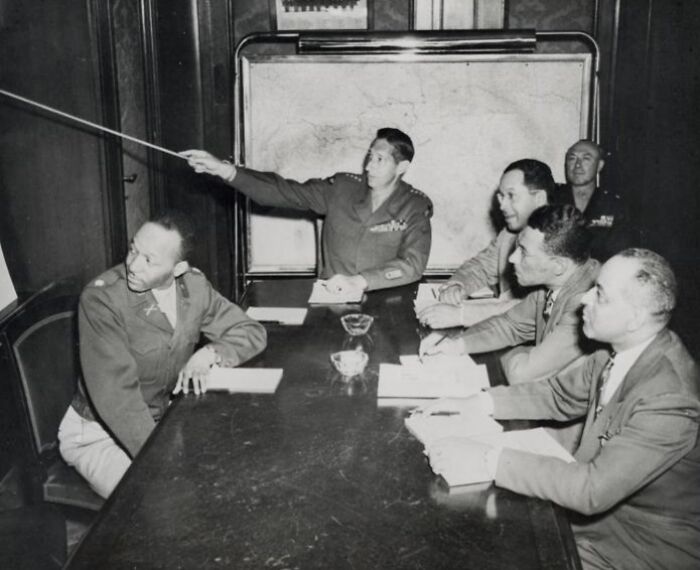African American military officers in uniform gathered around a table during a historical strategic meeting.