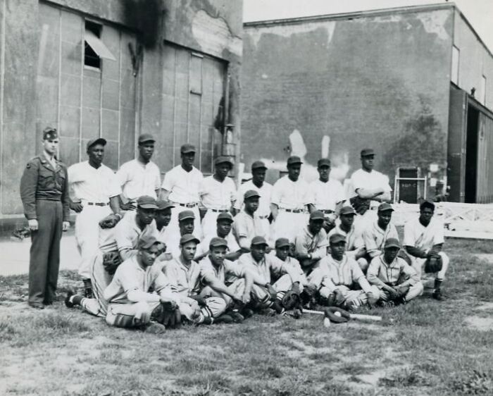 Historic black baseball team posing outdoors in uniforms, showcasing powerful African Americans in uniform through history.
