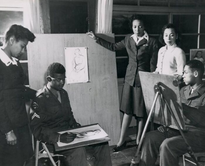 African Americans in uniform drawing sketches in a classroom setting, showcasing talent and discipline through history.