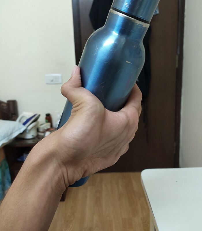 Hand holding a blue metal bottle indoors illustrating one-in-a-million coincidences that are hard to believe.