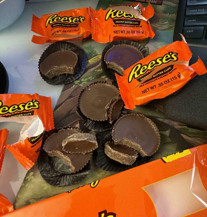Several opened Reese's peanut butter cups with bite marks on a table, illustrating one-in-a-million coincidences.