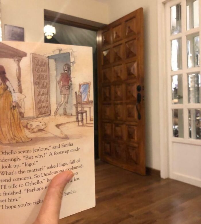 Hand holding a book page perfectly aligned with a wooden door, showing one-in-a-million coincidence in perspective.