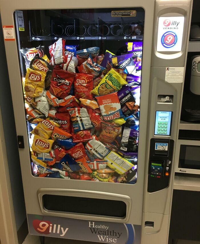 Vending machine packed unusually full with snack bags stacked together forming a one-in-a-million coincidence.