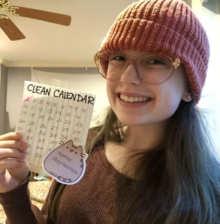 Young woman smiling and holding a clean calendar in a cozy room, representing people who asked the internet to toast them.