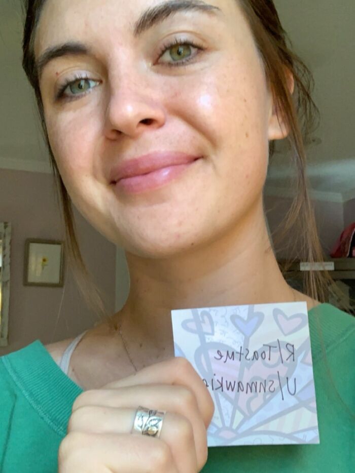 Young woman smiling at home holding a positive note, part of people who asked the internet to toast them collection.
