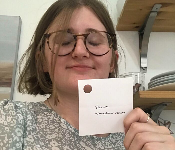 Young woman wearing glasses holding a toast request note, part of 80 people who asked the internet for toast comments.
