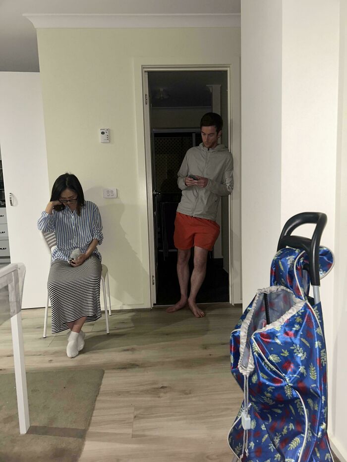 Two people looking stressed and distracted inside a dimly lit room, illustrating bad landlords and renting issues.