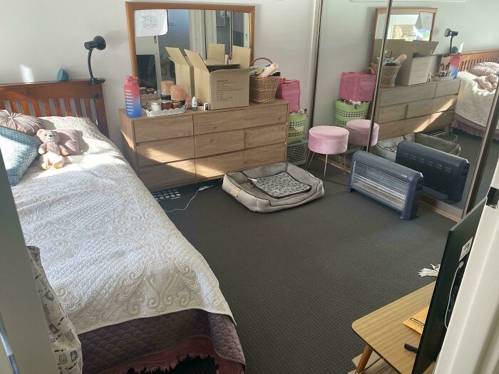 Small cluttered bedroom with basic furniture and poor maintenance showing issues of bad landlords in rental homes.