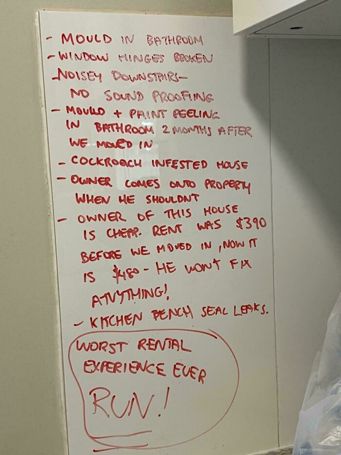 Handwritten list on whiteboard detailing issues with bad landlords and rental problems including mold, pests, and unresponsive repairs.