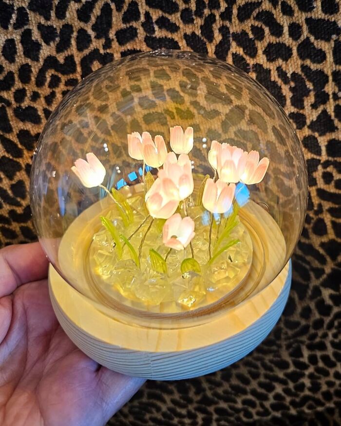 Hand holding a decorative glass globe with delicate pink flowers, one of the Amazon hidden gems.