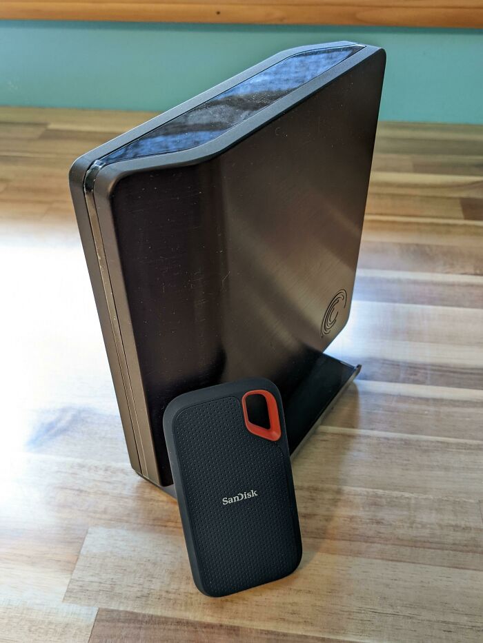 Comparison of old and new external hard drives side by side showing noticeable size and design change.