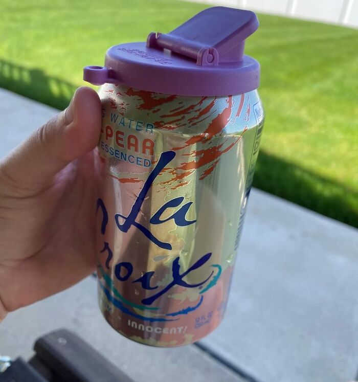 Hand holding pear La Croix can with purple reusable lid outdoors on a sunny day TikTok finds trending beverage accessory.