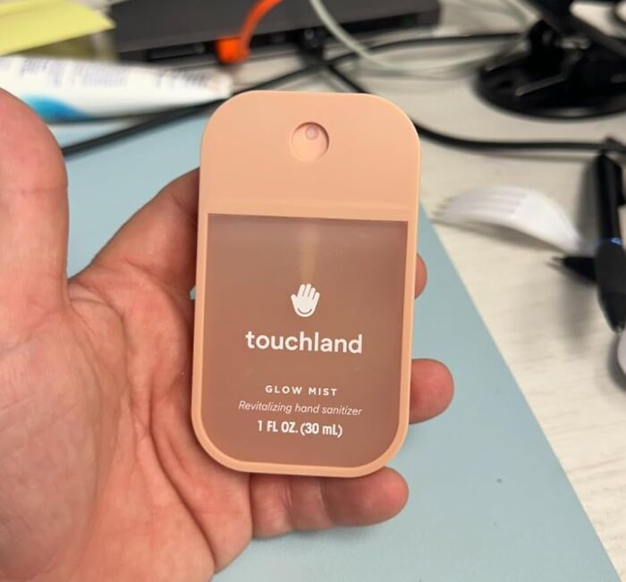 Hand holding a small Touchland glow mist hand sanitizer, one of the popular TikTok finds on the For You page.