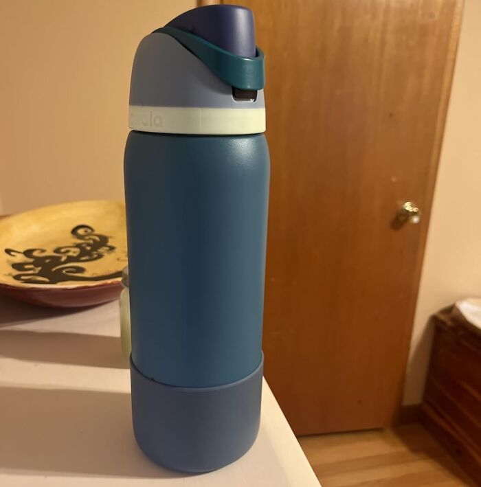 Blue water bottle with a flip-top lid placed on a kitchen counter among popular TikTok finds.