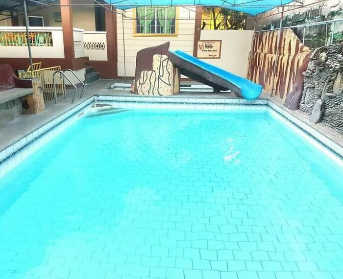 Indoor pool with a dangerously steep slide ending very close to pool edge in a dangerous design.
