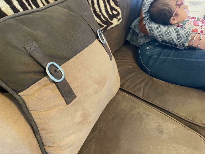 Close-up of a dangerous design pillow with buckle straps on a couch, illustrating a potential death trap hazard.