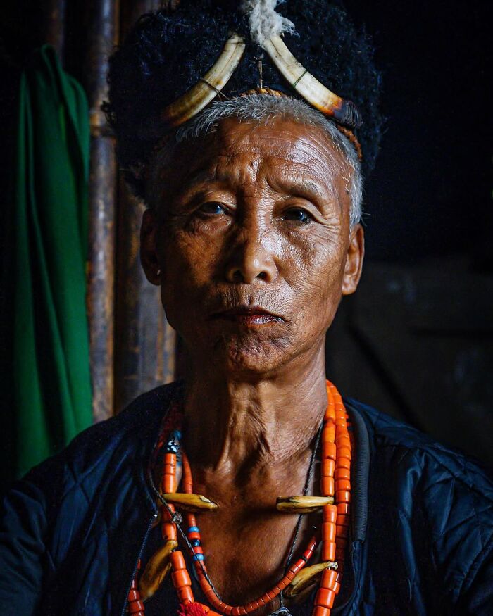 Elderly person with traditional jewelry and headdress, captured in a striking portrait showcasing diverse cultures globally.