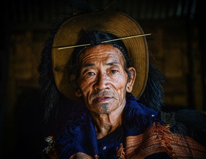Elderly man wearing traditional attire and a distinctive hat in a striking portrait by Massimo Bietti.