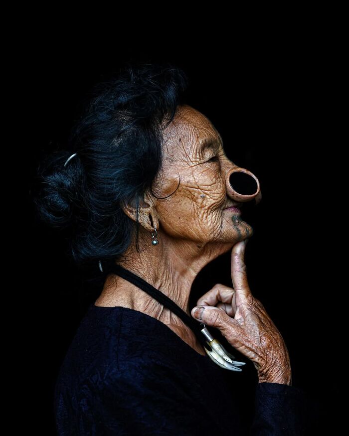 Elderly woman with traditional nose ornament and wrinkles in a striking portrait capturing cultural heritage and age.