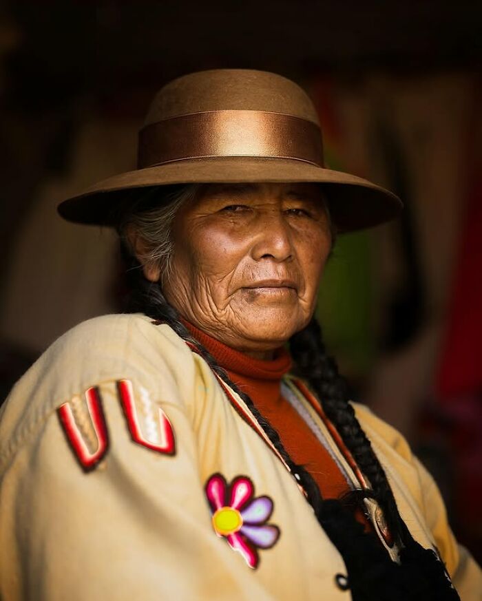 Portrait of an elderly person wearing a hat and traditional clothing, showcasing striking details of aging and culture.
