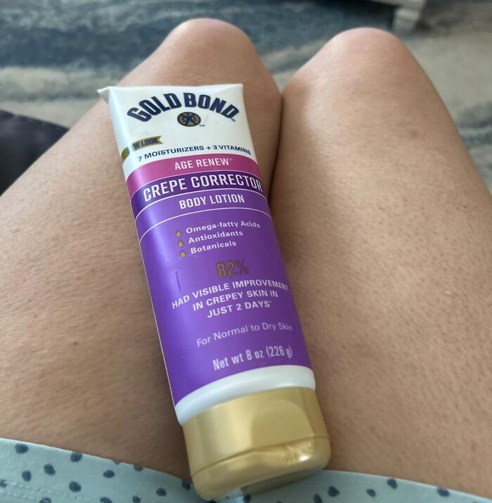 Gold Bond Age Renew Crepe Corrector body lotion held on bare legs, showcasing a bestselling skincare product.