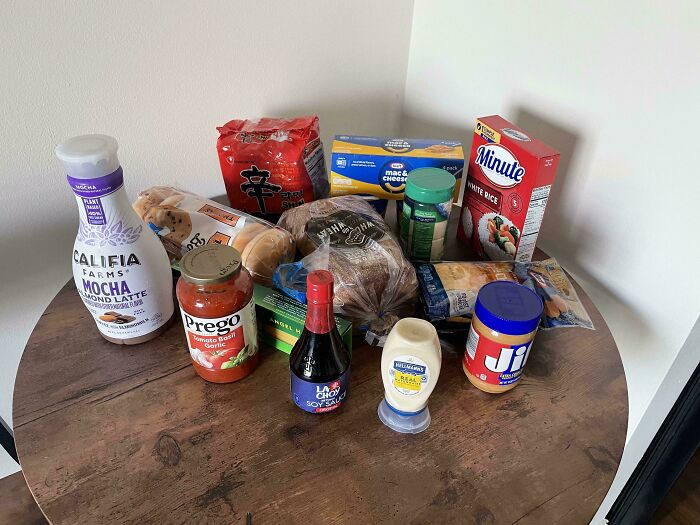 Various groceries including bread, peanut butter, rice, and sauce displayed to show local grocery costs.