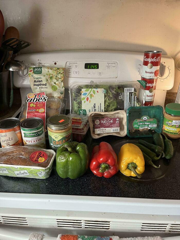 Various groceries including vegetables, canned goods, peanut butter, and salad displayed to show cost differences where people live.