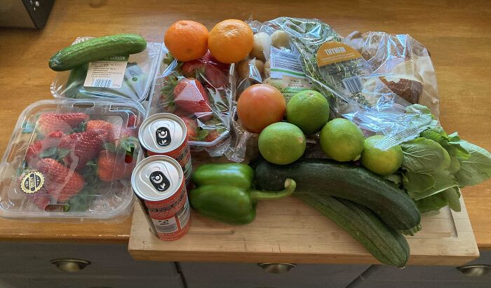 Assortment of groceries including fresh vegetables, fruits, drinks, and bread showing grocery cost variations locally.