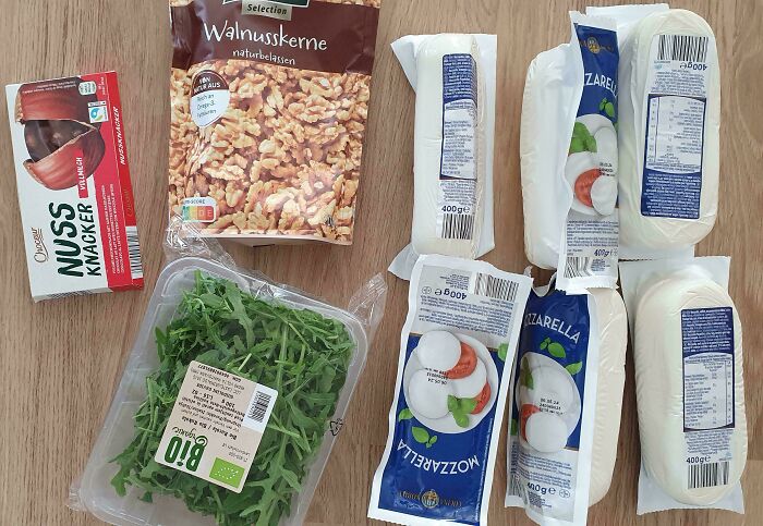 Groceries including mozzarella, walnuts, crackers, and greens displayed to show grocery cost variations.