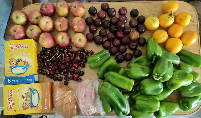 Various fresh fruits, vegetables, and packaged groceries laid out on a table showing grocery cost where they live.