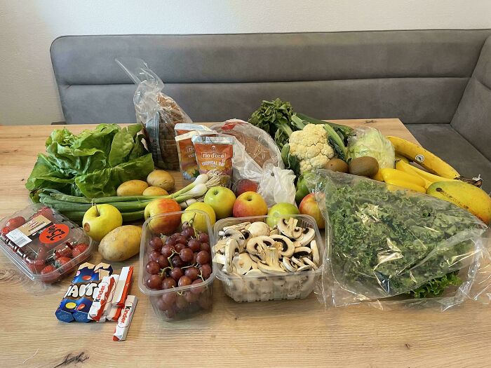 A variety of groceries including fruits, vegetables, bread, and snacks showing grocery cost comparison.