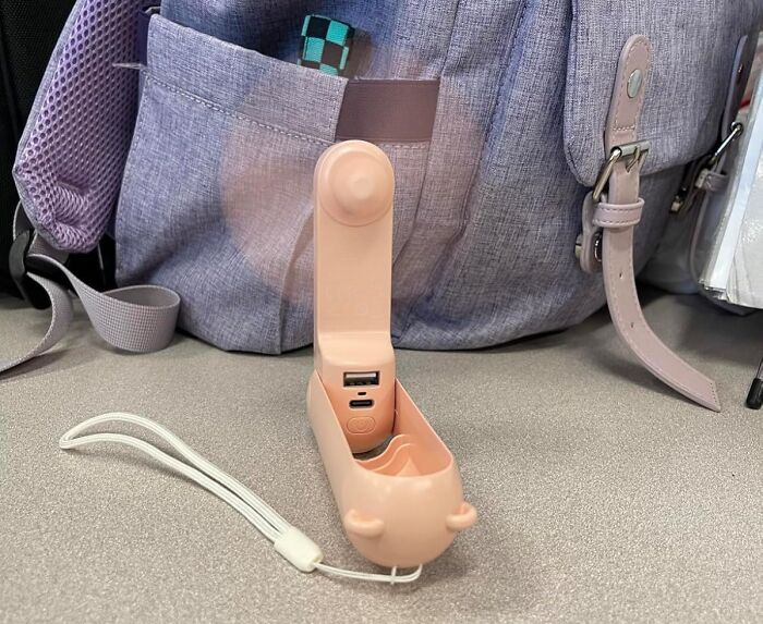 Portable internet gold product on Amazon with USB ports and small fan, placed on a table near a gray backpack.