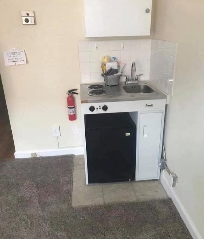 Tiny kitchen setup with small stove, sink, and mini fridge in a cramped space, illustrating worst real estate photos ever.