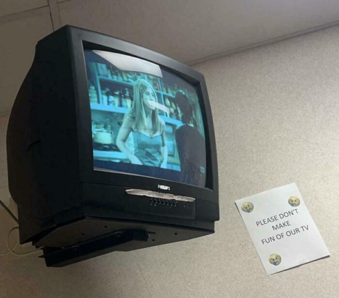 Vintage CRT television mounted on a wall playing a classic show, showcasing vintage devices in technology evolution.