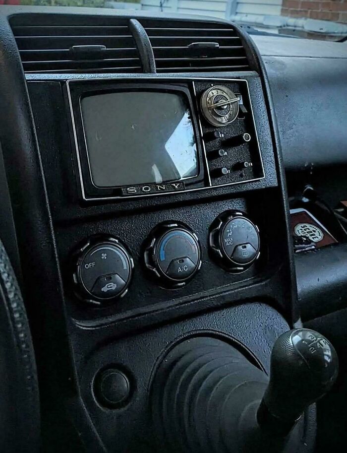 Vintage Sony car dashboard with a retro television and classic air conditioning controls, showcasing vintage devices technology.