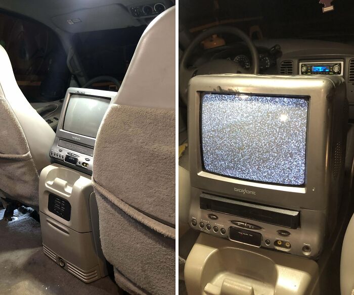 Vintage car entertainment system with an old CRT screen and DVD player showing static in the dark interior.