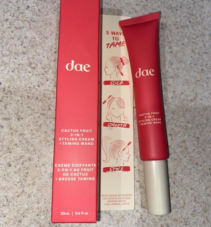 Red tube and packaging of dae cactus fruit 3-in-1 styling cream and taming wand, a viral summer essential for hair care.
