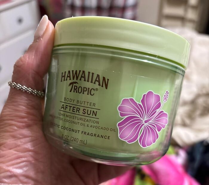 Hand holding Hawaiian Tropic body butter after sun with coconut fragrance, a must-have viral summer essential product.