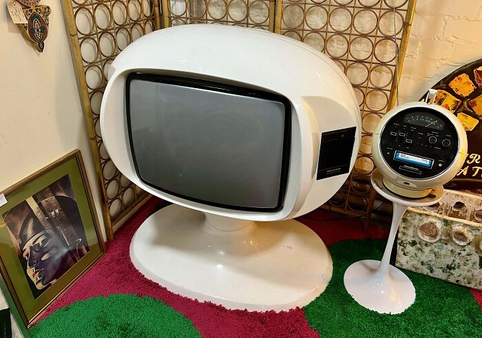 Vintage device featuring a retro futuristic television and a matching round control panel on a pedestal stand.
