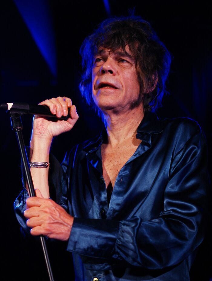 Singer performing on stage under blue lights, featured among notable people who passed away in 2025.