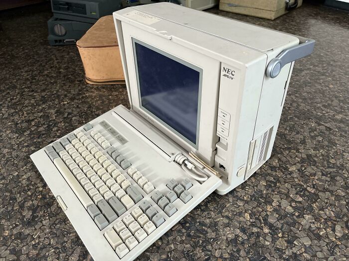 Vintage NEC portable computer with built-in keyboard and small screen, showcasing vintage devices in technology history.