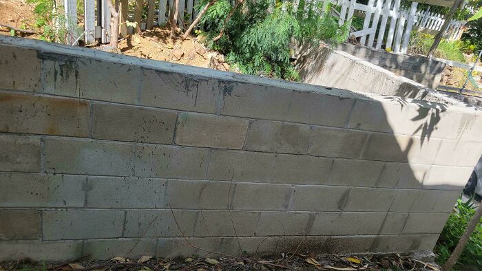 Concrete block wall with uneven finishes and a small gap, showcasing infuriating landlords’ poor landlord specials.